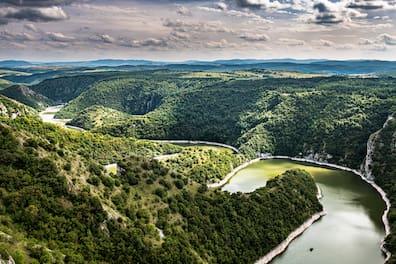 A river winds through forested mountain landscapes.