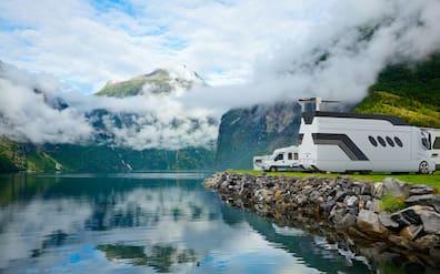 View of a mountainous landscape with several motorhomes parked at the edge.