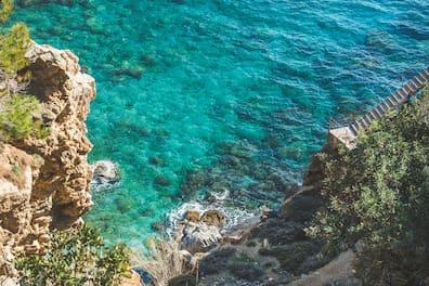 Staircases over rocks and a path down to the lagoon and turquoise sea on Turkey's southern Mediterranean coast near Koru Beach in the city of Gazipasa.