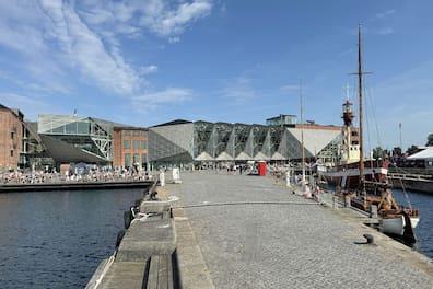 View of the glass buildings at the Culture Harbor in Helsingør and a sailboat anchored in front