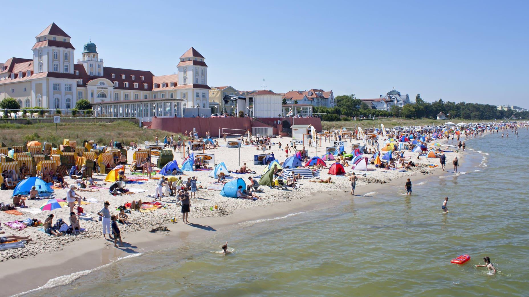 At the beach of the historic spa house in Binz on Rügen, many tourists are enjoying themselves.