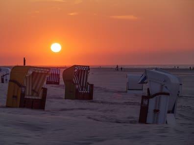Beach chairs on Juist offer a wonderful way to enjoy the sea and sunset.