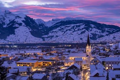 Winter in northern Liechtenstein: Behind the serenely lit church of Eschen, the Alpine panorama appears.