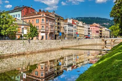 Buildings reflect in the Miljacka River flowing through Sarajevo.