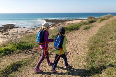 Two children on a hiking path over the coast of Costa de la Luz in Spain.