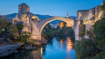 View from the river of the picturesque bridge in Mostar, illuminated at night.