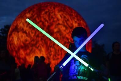 A boy with two lightsabers, known from the 'Star Wars' movies.