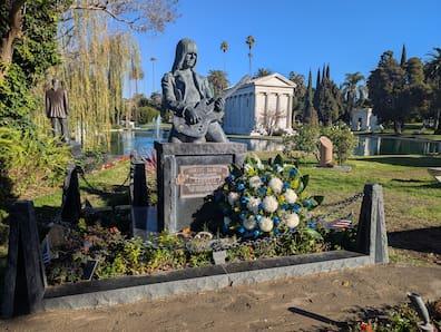 View of a grave with a large figure holding a guitar.