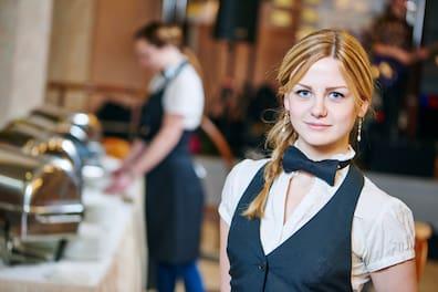 Service staff in front of a buffet.