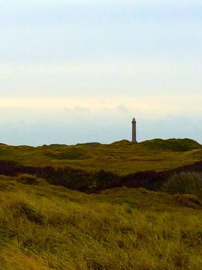 Surreal dune landscape with lighthouse.
