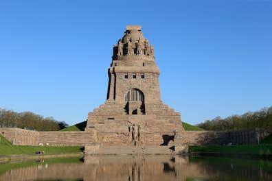 Monumental Battle of the Nations Monument made of dark stone and with a wall in Leipzig, in front of a moat