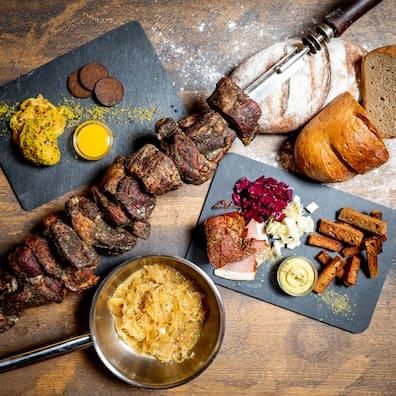 View of a set table with a meat skewer and various side dishes.