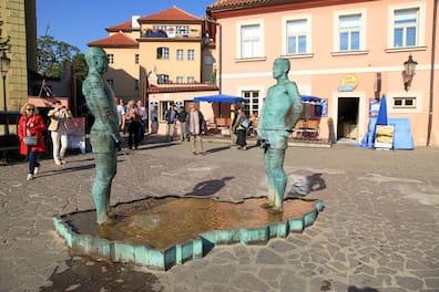Picture shows a plaza with two figures urinating into a pond shaped like the Czech Republic.