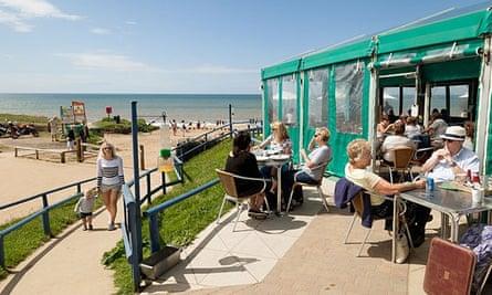 People eating at the Hive Beach cafe, Burton Bradstock, Dorset