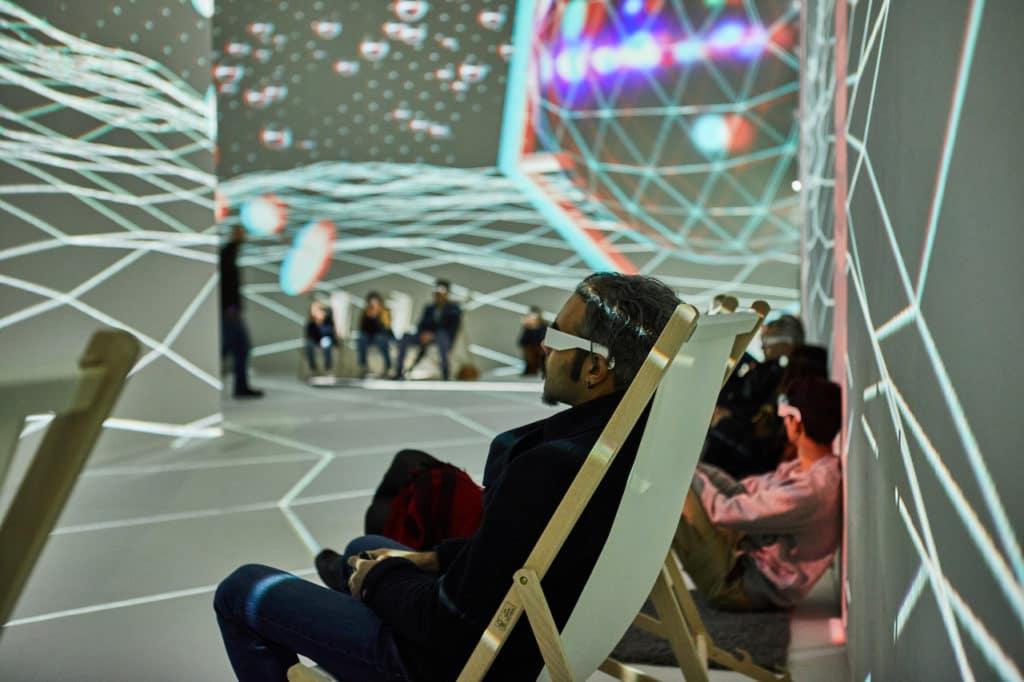 visitors reclining at the Dali : Cybernetics exhibition in the floor-to-ceiling projection room