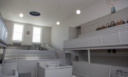 The Shire Hall courtroom at Shire Hall Historic Courthouse museum, Dorchester, Dorset, UK. The white-painted courtroom is empty except for a group of cardboard cutouts in the gallery section.